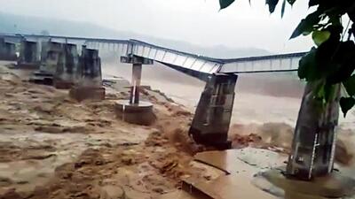 The railway bridge on the Chakki river collapses after one of its three pillars got damaged due to a flash flood triggered by heavy rainfall, in Kangra on Saturday. (ANI)