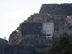 A semi-burnt building stands amid scorched area as wildfires remain active in the Valencia region, in Bejis, Spain.