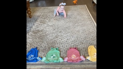 The image, taken from the viral Instagram video, shows a toddler approaching four lined-up clothes to choose her Hogwarts house.&nbsp; (Instagram/@derekbloom)