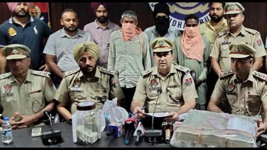 Police officials with the arrested accused and the drug money recovered from them in Jalandhar on Sunday. HT photo