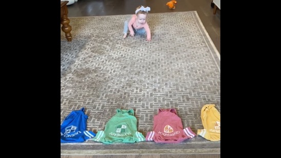 The image, taken from the viral Instagram video, shows a toddler approaching four lined-up clothes to choose her Hogwarts house.&nbsp;(Instagram/@derekbloom)