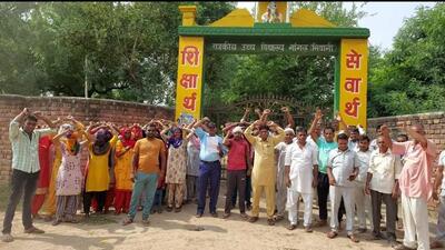 Villagers and students protesting against the new teachers’ transfer policy at Bhiwani village. (HT Photo)