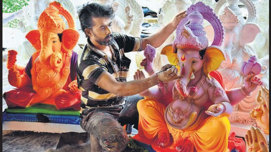 A sculptor gives final touches to a Ganesh idol at Walekhar wadi in Chinchwad. (HT PHOTO)