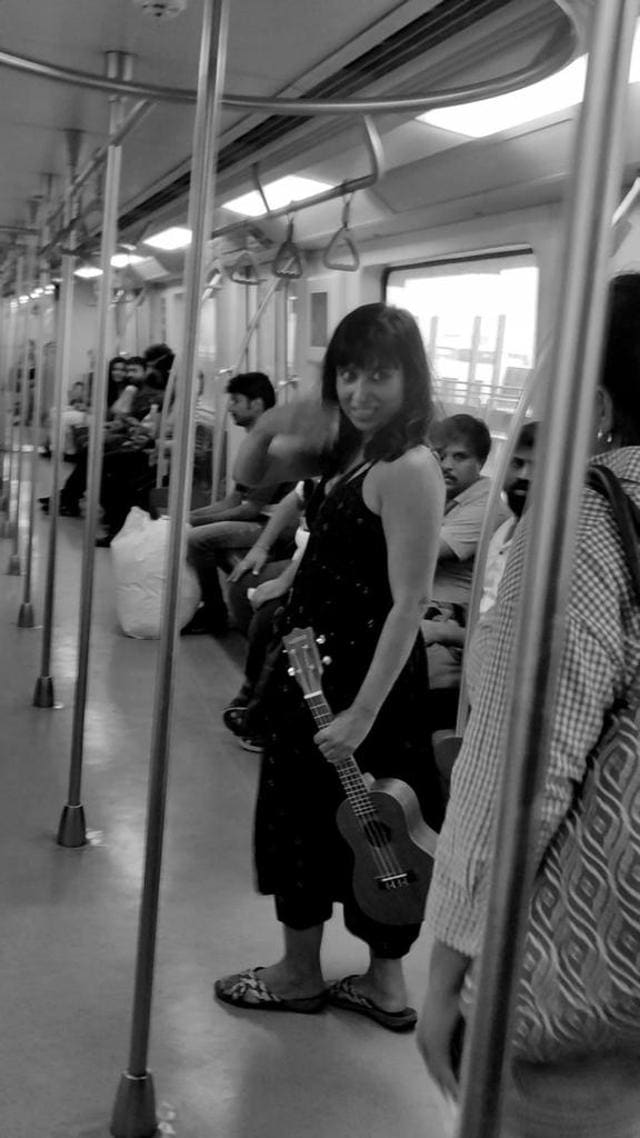 One of the team members of the Why Loiter campaign plays ukele on board the Mumbai metro