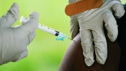 A health worker administers a dose of a Pfizer COVID-19 vaccine at a vaccination clinic. 