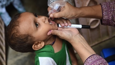 A health worker administers polio drops to a child during a polio vaccination campaign in Karachi on August 15, 2022. ((Photo by Rizwan TABASSUM / AFP)) A health worker administers polio drops to a child during a polio vaccination campaign in Karachi on August 15, 2022. ((Photo by Rizwan TABASSUM / AFP))