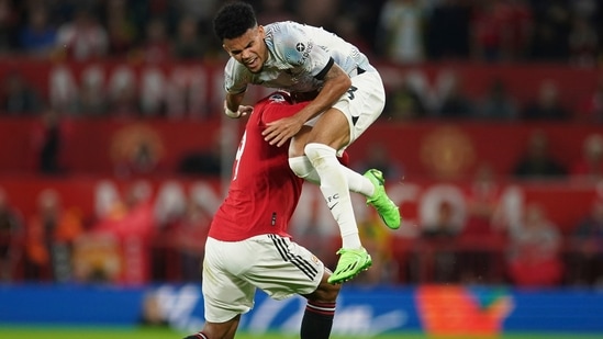 Luis Diaz is tackled by Raphael Varane during the Premier League match between Manchester United and Liverpool at Old Trafford.(AP)
