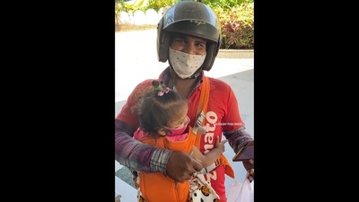 The image, taken from the viral video on Instagram, shows a Zomato delivery agent delivering food carrying his kids to work. (Instagram/@foodclubbysaurabhpanjwani )