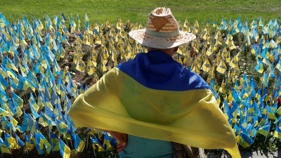 A man stands next to Ukrainian flags with names of service members, who are in Russian captivity, as Russia's attack on Ukraine continues, at the Independence square in Kyiv, Ukraine. (REUTERS)