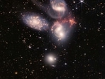 A group of five galaxies that appear close to each other in the sky: two in the middle, one toward the top, one to the upper left, and one toward the bottom are seen in a mosaic or composite of near and mid-infrared data from NASA's James Webb Space Telescope.&nbsp;