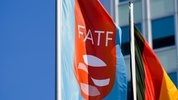 A flag with the logo of the Financial Action Task Force, FATF, waves in the wind next to the German national falg during a meeting of the task force at the Congress Center in Berlin, Germany.