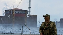 A serviceman with a Russian flag on his uniform stands guard near the Zaporizhzhia Nuclear Power Plant outside the Russian-controlled city of Enerhodar.