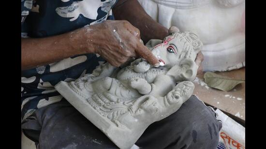 An artisan takes a little more than an hour to finish colouring a Ganesh idol (Photo: Dhruv Sethi/HT)