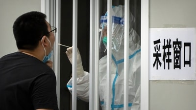A worker wearing a protective suit swabs a man's throat for a Covid-19 test at a coronavirus testing site in Beijing. (AP) A worker wearing a protective suit swabs a man's throat for a Covid-19 test at a coronavirus testing site in Beijing. (AP)