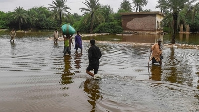 Residents wade through a flooded street after heavy monsoon rainfalls in Sukkur of Sindh province, southern Pakistan. (AFP)