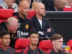 Manchester United' Cristiano Ronaldo, centre, gestures as he sits with teammates, prior to the start of a Premier League match.