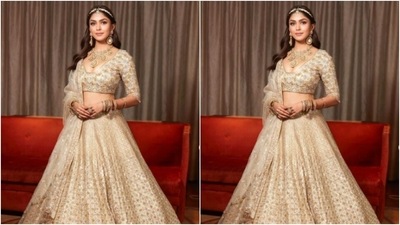 Mrunal decked up in white and golden embroidered blouse with a sweetheart neckline and teamed it with a long flowy white and golden skirt that came heavily embroidered in resham threads and zari work. (Instagram/@mrunalthakur)
