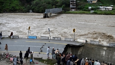 People gather next to a section of a road damaged by flood waters following heavy monsoon rains in Madian area in Pakistan's northern Swat Valley. (AFP) People gather next to a section of a road damaged by flood waters following heavy monsoon rains in Madian area in Pakistan's northern Swat Valley. (AFP)