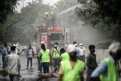Fire officials sprinkling water on the road to settle the dust in Noida. (Raj K Raj/HT) Fire officials sprinkling water on the road to settle the dust in Noida. (Raj K Raj/HT)
