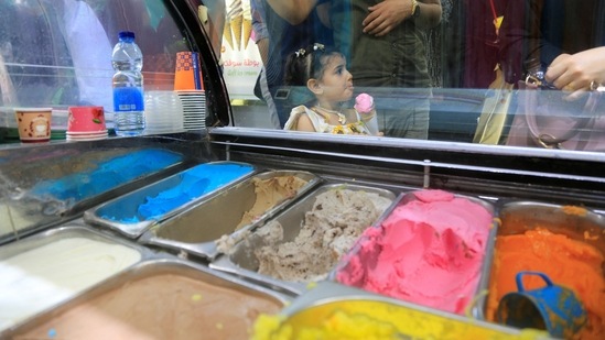 Palestinian girl eats ice cream in Kathem ice cream shop, as heat and lengthy power cuts melt ice cream shops' profits, in Gaza City.(REUTERS)