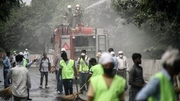 Noida Worker showering the Road to control the dust after the controlled implosion demolishes the 100-metre-high residential "Twin Towers" in Noida on the outskirts of New Delhi on Sunday.