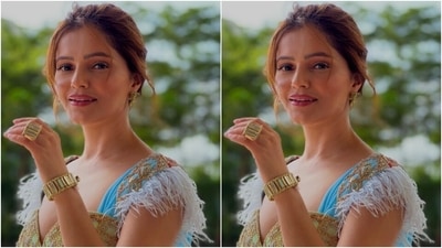 Rubina teamed her saree with a heavily embellished golden blouse that came with patterns in blue at the shoulders. The blouse featured a plunging neckline and added more dramatic vibes with white feather-like details at the shoulders. (Instagram/@rubinadilaik)