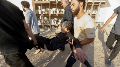 People carry a man amidst a protest of suporters of Iraqi populist leader Muqtada al-Sadr at the Green Zone, in Baghdad, Iraq August 29, 2022.&nbsp; (REUTERS)