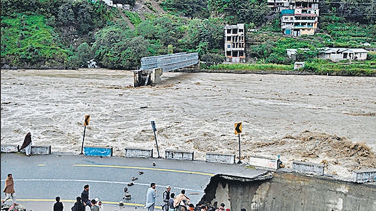 People watch as a section of a road sinks in Pakistan’s northern Swat Valley. (AFP)