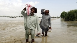 Pakistani men receive food, distributed by Pakistani Army troops in a flood-hit area in Rajanpur, district of Punjab, Pakistan, Aug. 27, 2022.