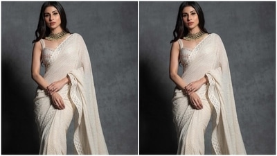 Mouni Roy's ivory saree comes decked with sequin embellishments and scalloped gota patti embroidered on the border adorned with shimmering beads. The star draped the six yards in traditional style around her body, letting the pallu fall from her shoulder in a floor-grazing train. (Instagram) Mouni Roy's ivory saree comes decked with sequin embellishments and scalloped gota patti embroidered on the border adorned with shimmering beads. The star draped the six yards in traditional style around her body, letting the pallu fall from her shoulder in a floor-grazing train. (Instagram)