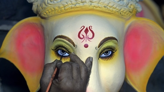 An artisan gives final touches to an eco-friendly idol of the Hindu god Lord Ganesha at a workshop. (AFP)