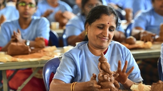 People make eco-friendly Lord Ganesha idols to achieve the Guinness record for the 'most people sculpting modelling clay simultaneously' ahead of Ganesh Chaturthi festival, in Bengaluru.(PTI)