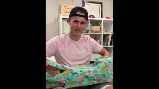 The image, taken from the viral Instagram video, shows a man unwrapping a gift from his wife.&nbsp;(Instagram/@coralwocknitz)