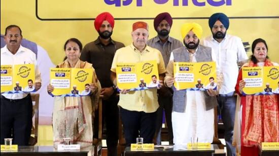 Punjab chief minister Bhagwant Mann and Delhi deputy chief minister Manish Sisodia with other AAP leaders at the launch of the party’s fourth guarantee at Palampur in Kangra district on Wednesday. (HT Photo)