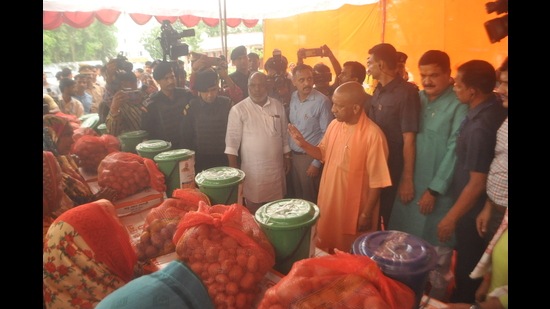UP CM Yogi Adityanath distributing relief material to flood-affected people in Varanasi on Wednesday. (HT Photo)