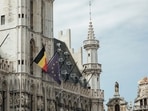 A Belgian national flag and a European Union (EU) flag outside the town hall at Grand Place in the old town area of Brussels, Belgium. EU stops visa ban for Russians but complicates travel rules amid war in Ukraine.&nbsp;(Photographer: Cyril Marcilhacy/Bloomberg)