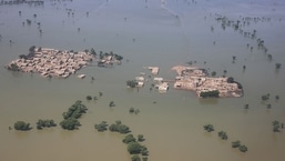 TOPSHOT - Esta fotografia aérea tirada na quinta-feira mostra uma área residencial inundada após fortes chuvas de monção no distrito de Dadu, na província de Sindh, no Paquistão.