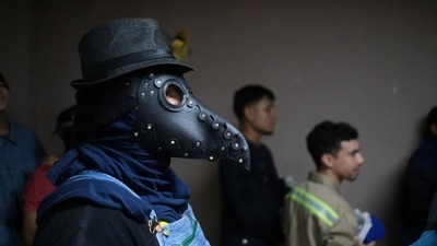 Masked men wait to participate in the festival that dates back to 1922. (REUTERS)