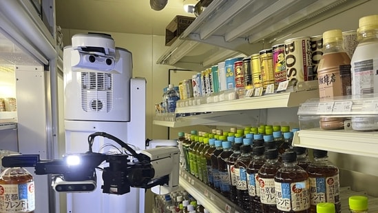 TX SCARA robot works, stocking drinks in the refrigerated section of a FamilyMart convenience store in Tokyo, Friday, Aug. 26, 2022.. (AP Photo/Yuri Kageyama)