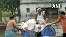 बिहार के भागलपुर जिले में लोग अस्थायी नाव को घुटने तक गहरे पानी में धकेल देते हैं.  (स्क्रीनग्रैब/एएनआई वीडियो)