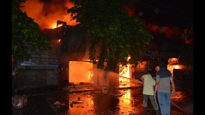 The shop owners and their kin look through the debris after the fire, on Friday morning. (SANT ARORA/HT) The shop owners and their kin look through the debris after the fire, on Friday morning. (SANT ARORA/HT)