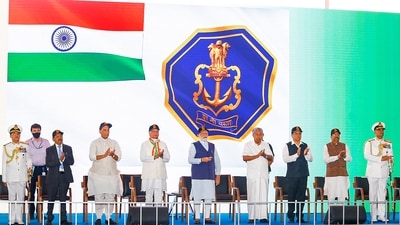 Also on this day, the Navy switched to a new ensign, as seen in the background, during the launch of the carrier. (PTI) Also on this day, the Navy switched to a new ensign, as seen in the background, during the launch of the carrier. (PTI)