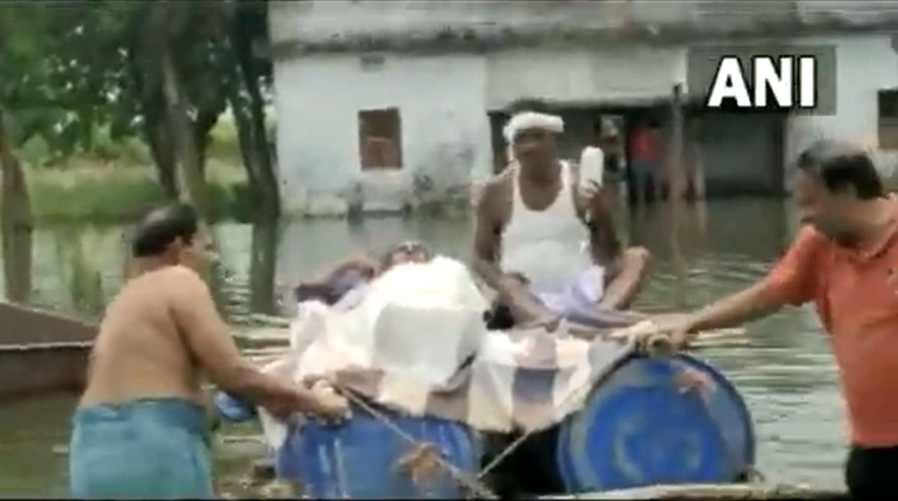 People push the makeshift boat in knee-deep water in Bihar's Bhagalpur district. (Screengrab/ANI video)