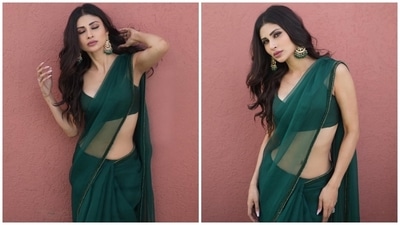 Mouni's see-through champagne green saree comes in a see-through silhouette and features shimmering sequinned patti embroidered on the borders. The actor draped the six yards around her svelte frame in traditional style, pleating the pallu on her shoulders and flaunting her toned midriff. (Instagram)