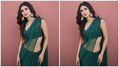 Mouni wore the sheer saree with a matching green blouse featuring spaghetti straps, a plunging neckline showing off her décolletage, cropped hem length and bodycon fitting. A pair of ornate gold jhumkis with emerald green beads, rings, and high heels completed the look. (Instagram)