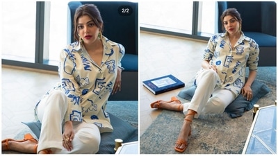 Kajal Aggarwal's clothing is the ideal inspiration for you if your vibe is simple. Her attire is both comfortable and fashionable. She was clothed in an off-white t-shirt outfit with blue patterns on it featuring different figures. The diva went all glam with her cosmetics, sporting red lipstick and&nbsp;flushed cheeks. She&nbsp;brightened the look with orange heels, bold earrings, and rings. (Instagram/@kajalaggarwalofficial)