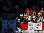 Manchester United fans display banners in protest of the Glazer family’s ownership of the club.