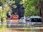 Members of a rescue team row their boat past submerged vehicles following torrential rains in Bengaluru, India, September 5, 2022. (REUTERS/Samuel Rajkumar)