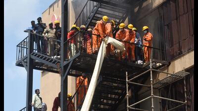 Firefighters using a ventilation pipe to rescue people during fire at the hotel in Lucknow on Monday. (Deepak Gupta/HT Photo)