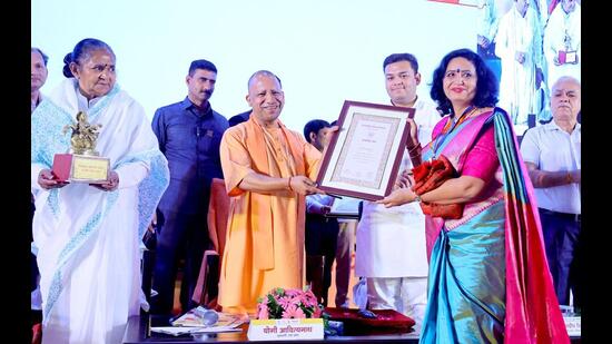 UP CM Yogi Adityanath felicitating teachers at the function. (HT Photo)